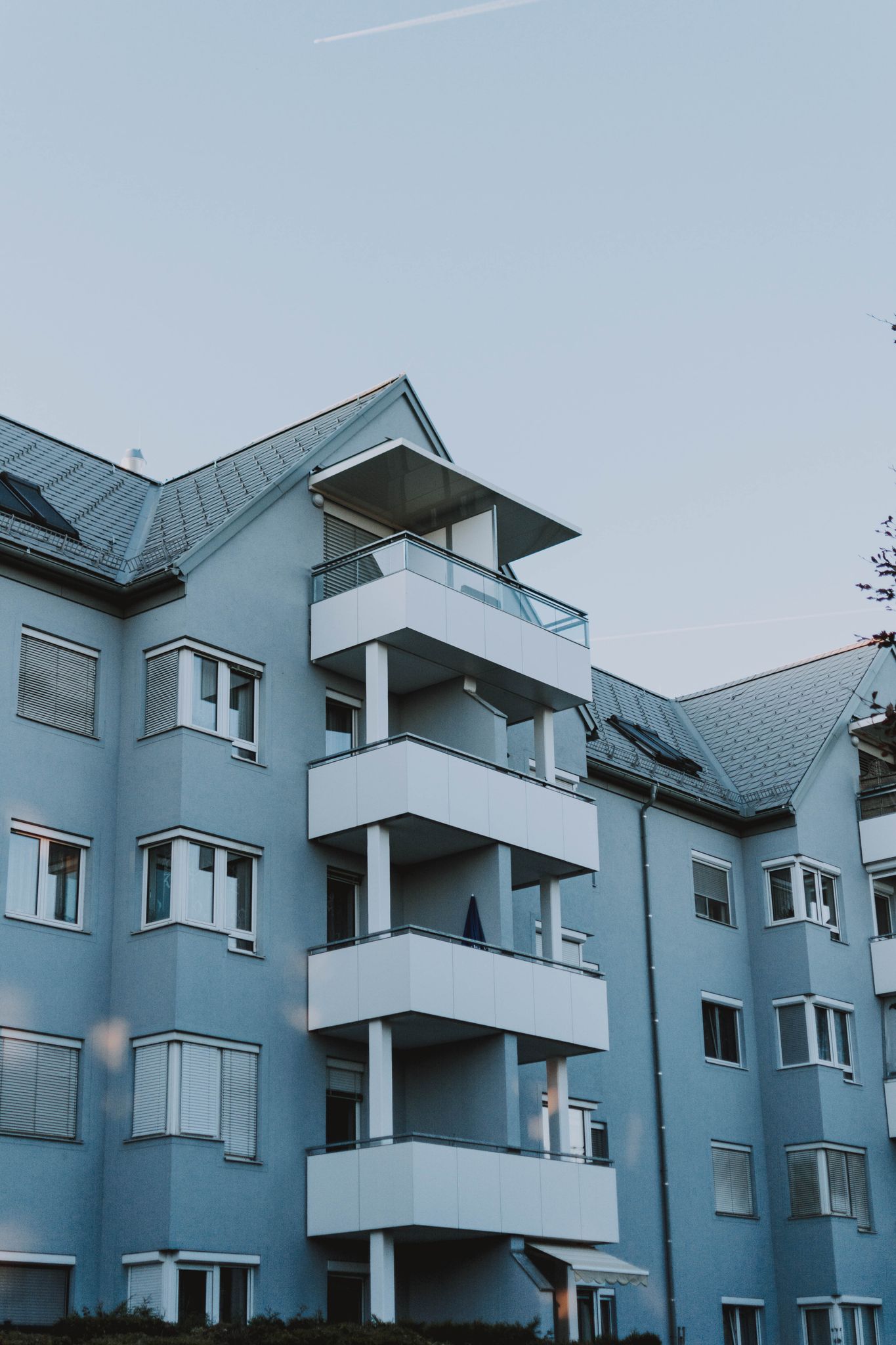 Contemporary architecture of an apartment building with balconies against a clear sky.